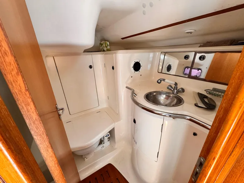Compact bathroom in 2002 X-Yachts X-382 sailboat with sink, toilet, and mirror.