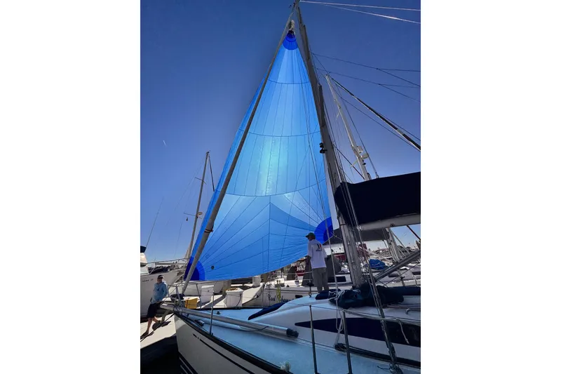 2002 X-Yachts X-382 sailboat with blue sails docked at marina.