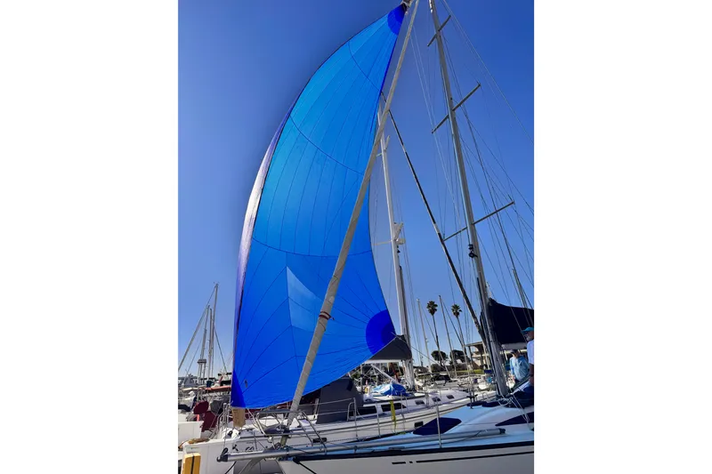 Blue sail on 2002 X-Yachts X-382 in marina under clear sky.