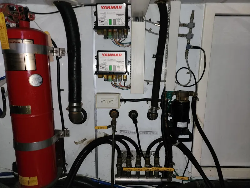Engine room of 2007 Ocean Alexander Veloce yacht with Yanmar components and fire extinguisher.