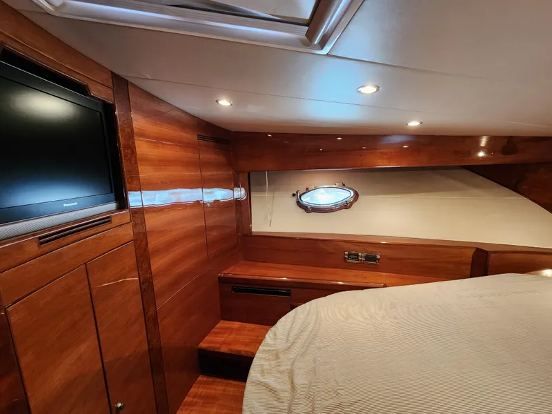 Luxurious 2007 Ocean Alexander Veloce yacht cabin with wood paneling and porthole window.