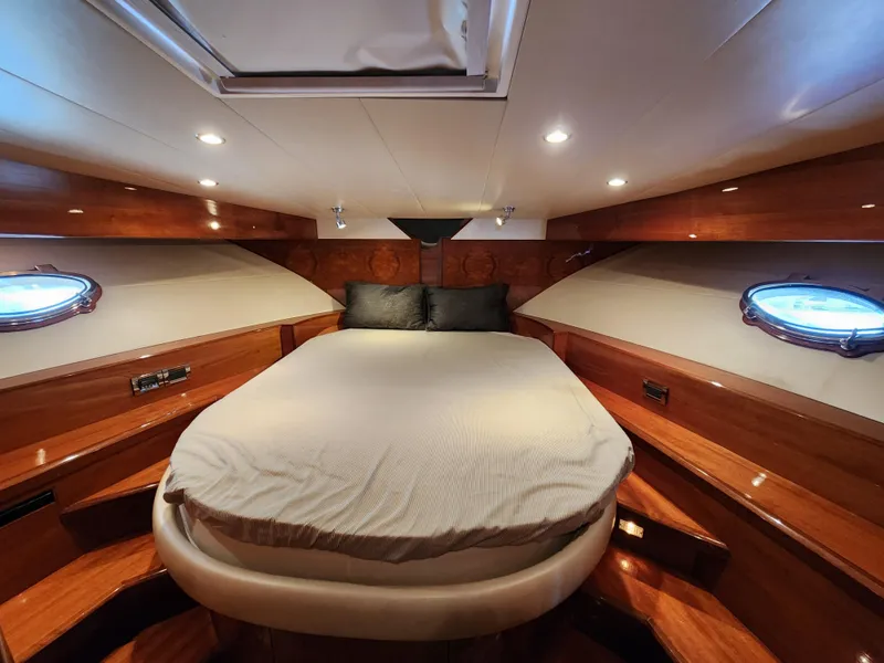 Luxurious 2007 Ocean Alexander Veloce yacht cabin with elegant wood finish and cozy bedding.