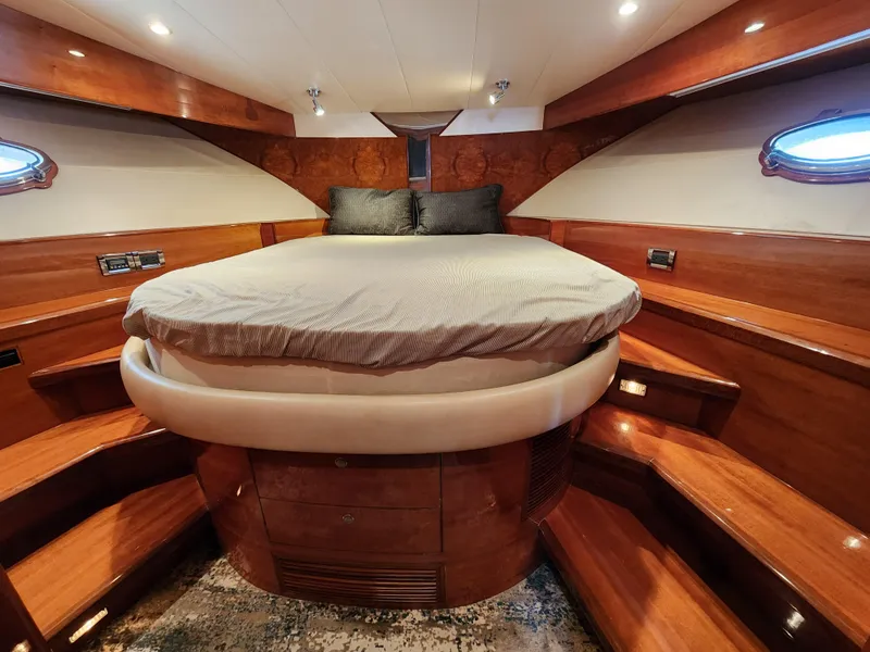 Luxurious 2007 Ocean Alexander Veloce yacht bedroom with elegant wood finish and cozy lighting.