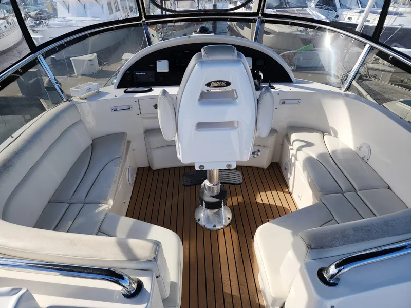 2007 Ocean Alexander Veloce yacht helm with white seating and wooden deck.