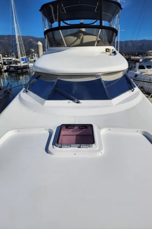 2007 Ocean Alexander Veloce yacht, sleek design, docked in marina under clear blue sky.