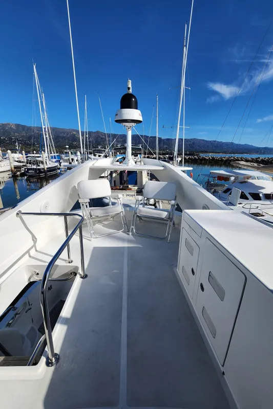 2007 Ocean Alexander Veloce yacht deck with seating, docked in a marina under clear blue skies.