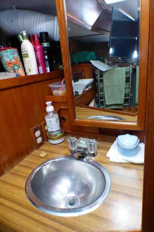 1984 Spindrift 39 ft. Aft Cabin bathroom with sink, mirror, and toiletries.