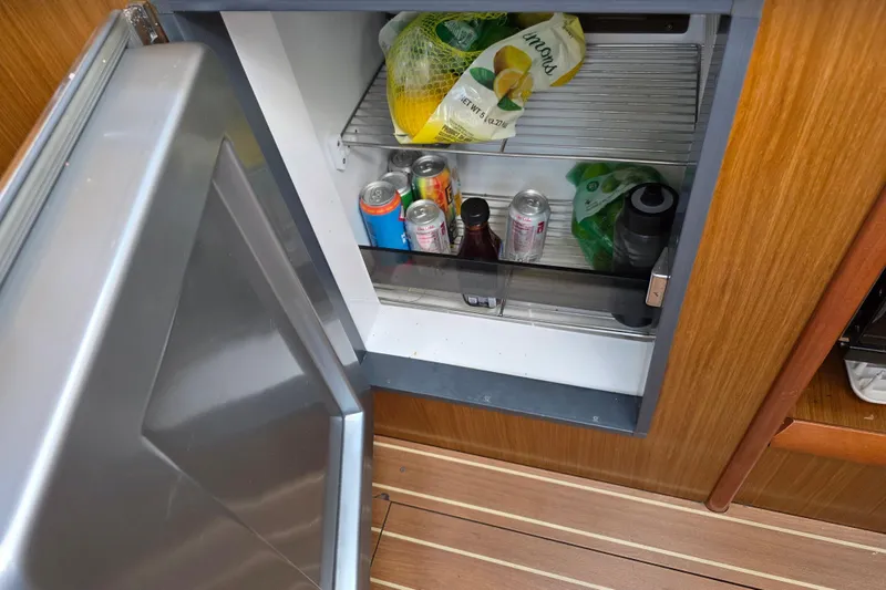 Open fridge on 2007 Jeanneau 49 Performance yacht with drinks and lemons inside.