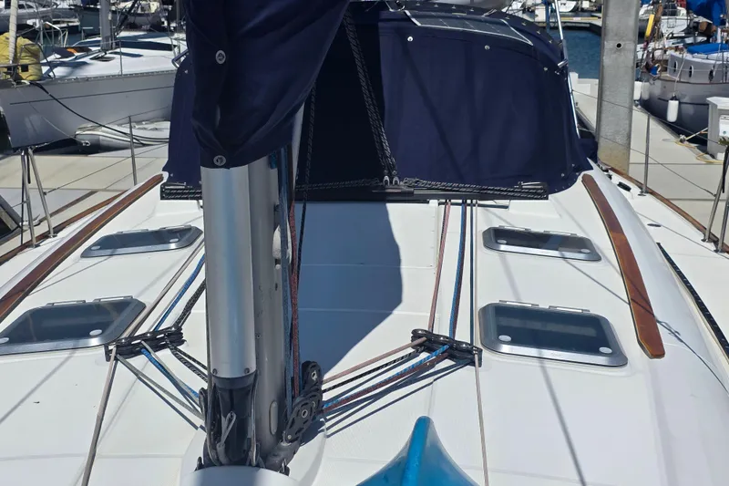 2007 Jeanneau 49 Performance sailboat deck with rigging and hatches in marina.