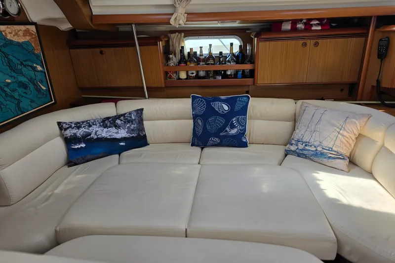 Luxurious interior of 2007 Jeanneau 49 Performance yacht with plush seating and decorative pillows.