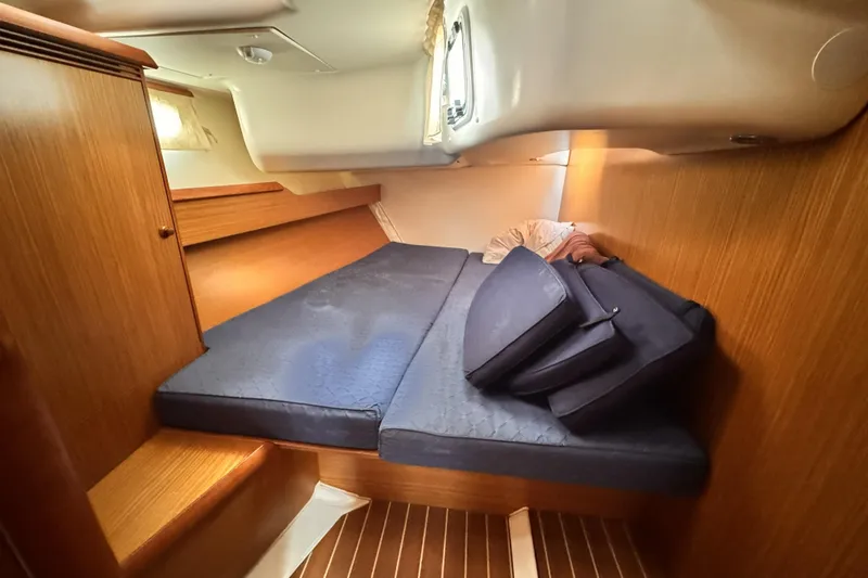 2007 Jeanneau Sun Odyssey 49 Performance cabin with blue cushions and wooden interior.