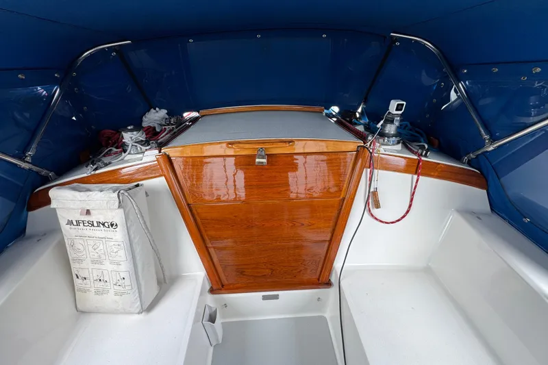 1991 Catalina 36MKI sailboat cockpit with wooden hatch, blue canopy, and safety equipment.