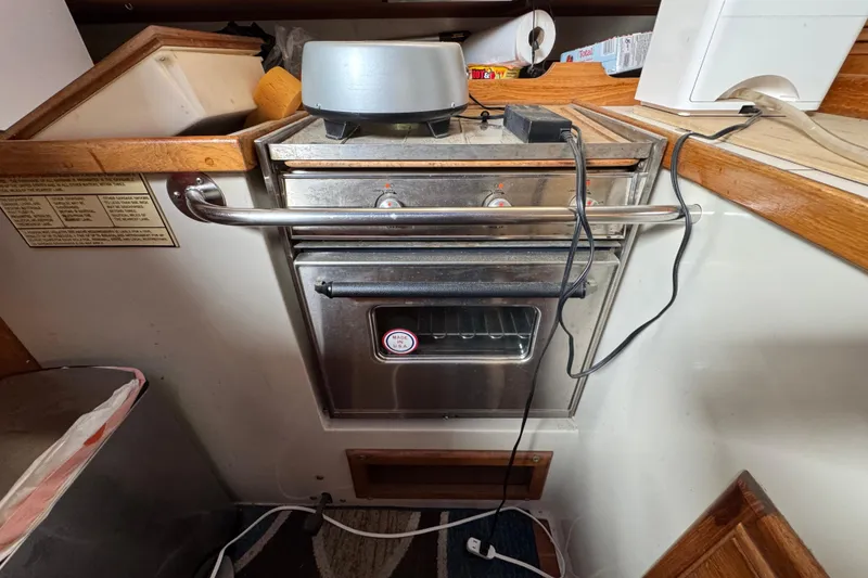 Stainless steel oven in 1991 Catalina 36MKI yacht kitchen, with wooden trim and appliances.