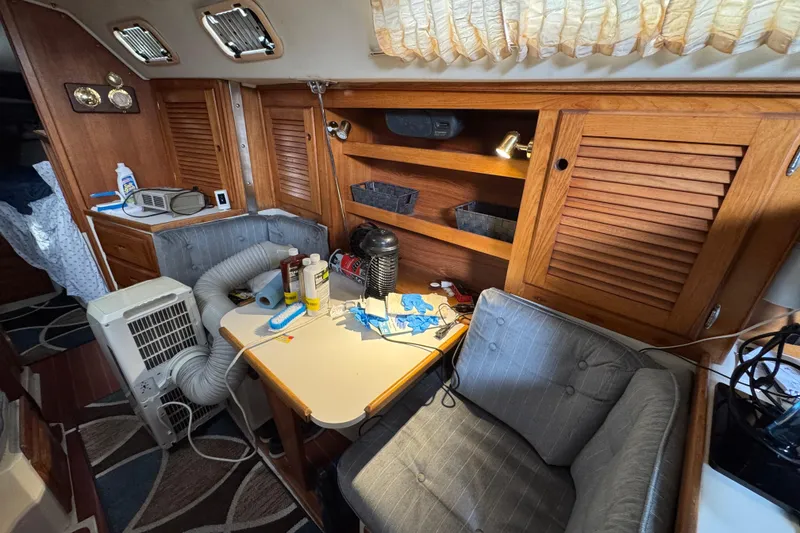 Interior of 1991 Catalina 36MKI sailboat with wooden cabinets and cozy seating area.