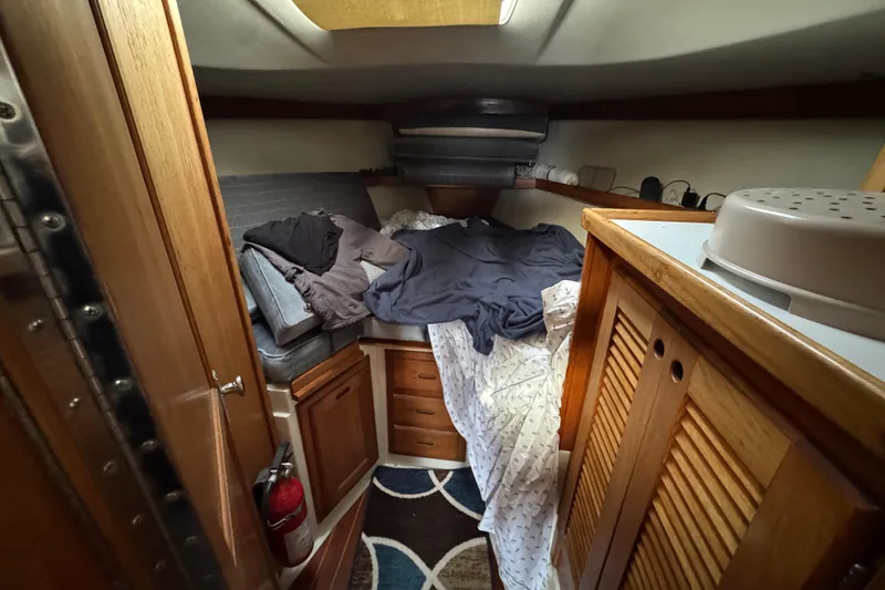 Cozy cabin interior of 1991 Catalina 36MKI sailboat with wooden furnishings and bedding.