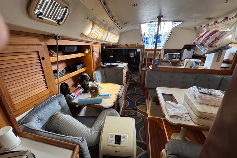 Interior of a 1991 Catalina 36MKI sailboat with cozy seating and wooden cabinetry.