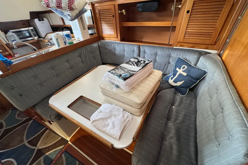 Cozy dining area in 1991 Catalina 36MKI sailboat with anchor-themed decor.