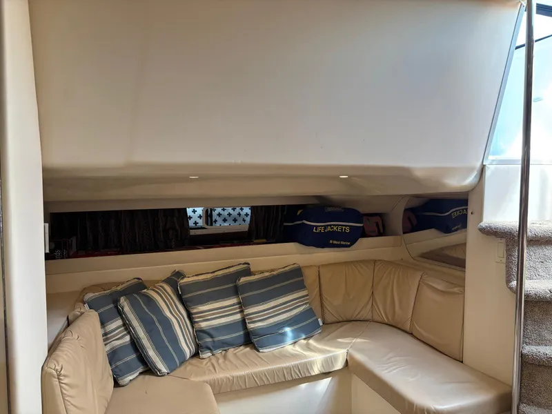 Interior of a 1998 Trojan 400 yacht with beige seating and striped cushions.