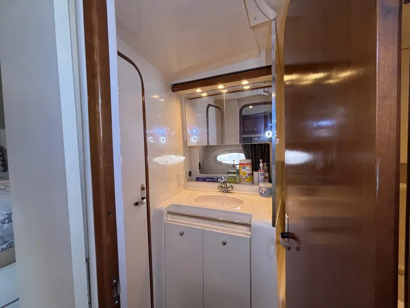 1998 Trojan 400 yacht bathroom with sink, mirror, and storage cabinets.