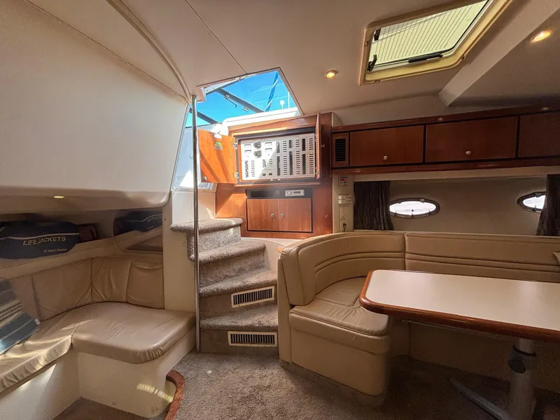 Interior of a 1998 Trojan 400 yacht with beige seating and wooden cabinetry.