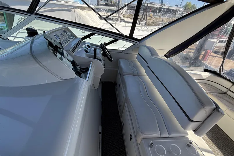 Interior of a 1998 Trojan 400 yacht with white seating and control panel.