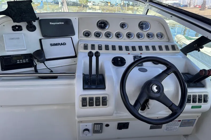 Cockpit of a 1998 Trojan 400 boat with steering wheel and navigation controls.