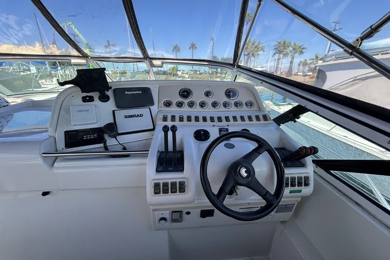1998 Trojan 400 boat cockpit with steering wheel, controls, and navigation equipment.