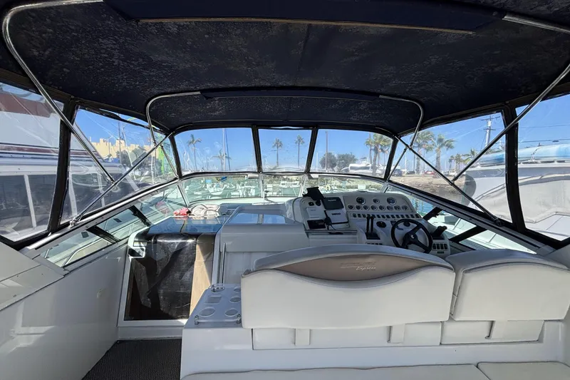 1998 Trojan 400 boat cockpit with steering wheel, control panel, and seating under canopy.