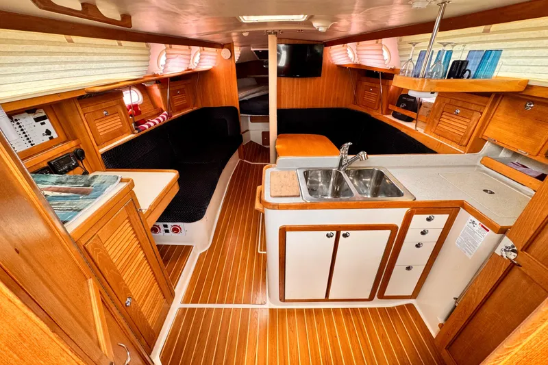 Interior of a 2006 Catalina 34 MkII sailboat with wood finish and compact kitchen.