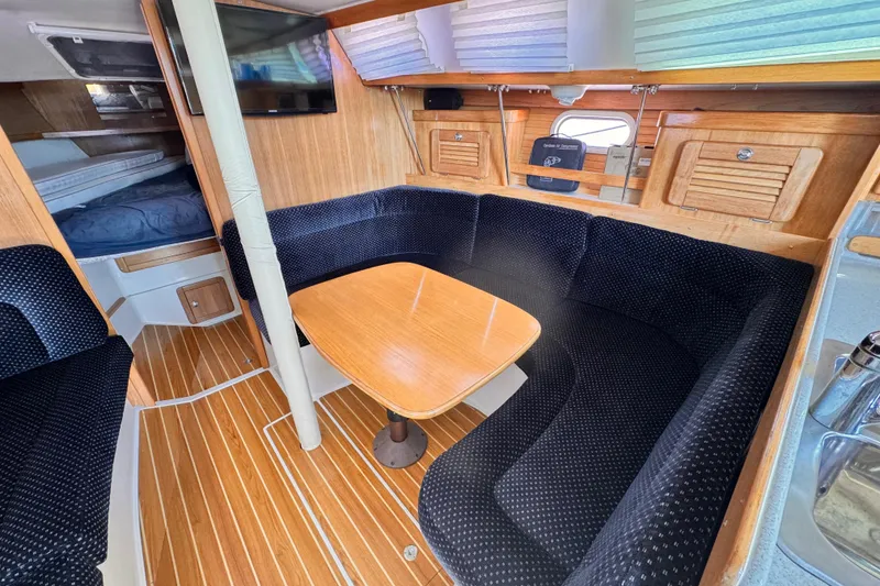 Interior of 2006 Catalina 34 MkII sailboat with cozy seating and wooden table.