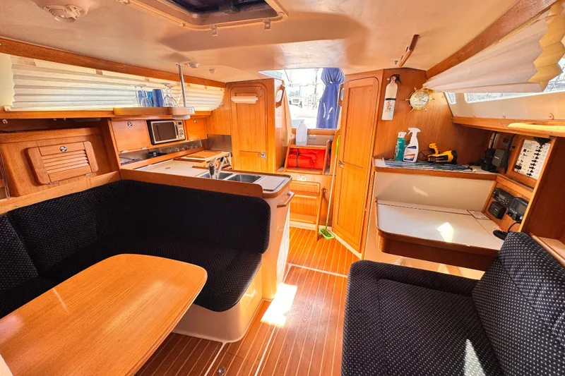 Interior of 2006 Catalina 34 MkII sailboat with cozy seating and wooden cabinetry.