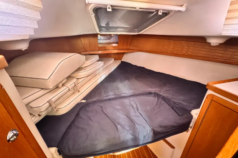 Cozy cabin interior of 2006 Catalina 34 MkII sailboat with cushions and wooden accents.