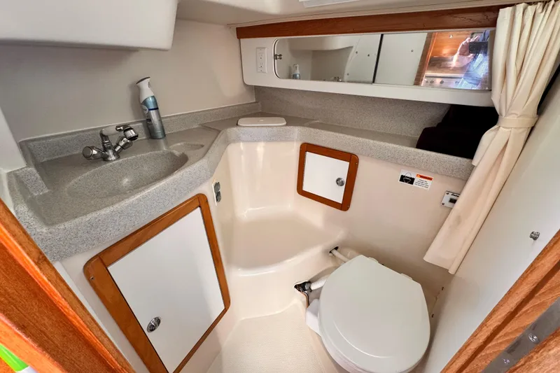 2006 Catalina 34 MkII yacht bathroom with sink, toilet, and storage cabinets.