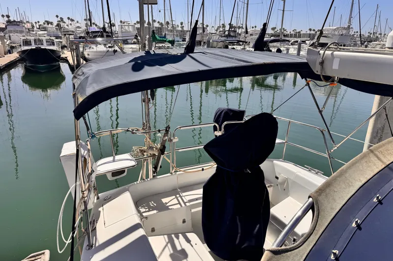 2006 Catalina 34 MkII sailboat docked in marina, featuring covered cockpit and calm waters.