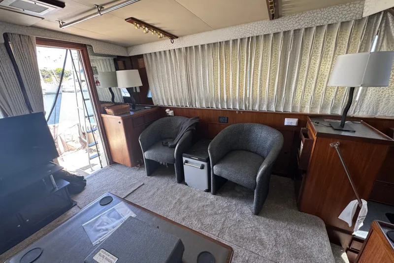 Interior of 1985 Hatteras 45 Convertible yacht with chairs and lamps.