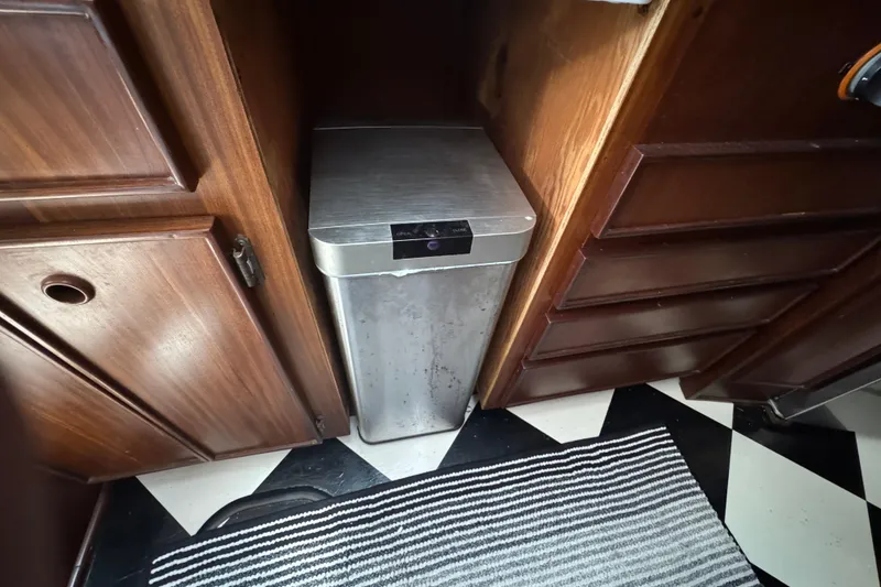 Trash bin in wooden cabinet space on 1985 Hatteras 45 Convertible yacht.