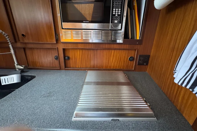 Galley kitchen in 1985 Hatteras 45 Convertible yacht with microwave and sink.