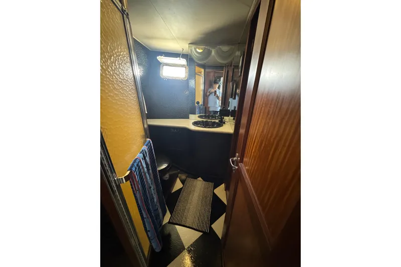 Bathroom interior of 1985 Hatteras 45 Convertible yacht, featuring a sink and window.