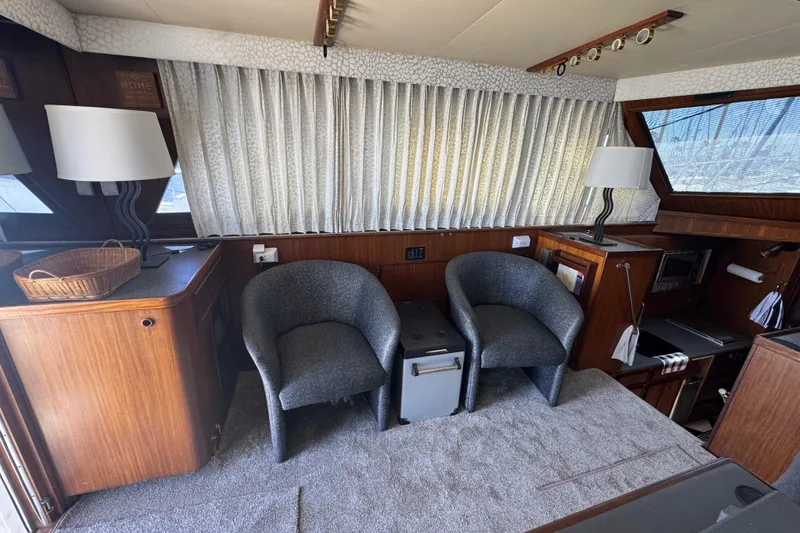 Interior of 1985 Hatteras 45 Convertible yacht with chairs and wooden cabinetry.