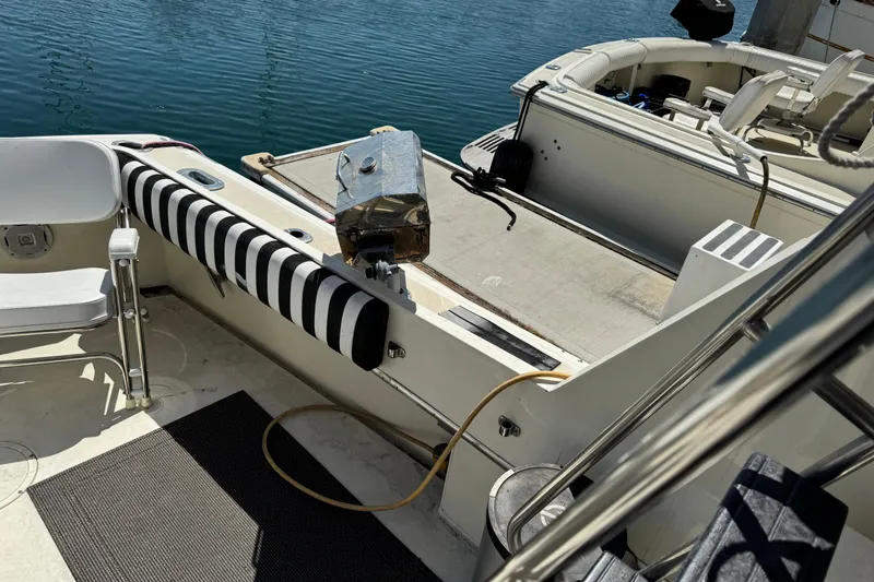 1985 Hatteras 45 Convertible yacht deck with striped padding and seating by the water.