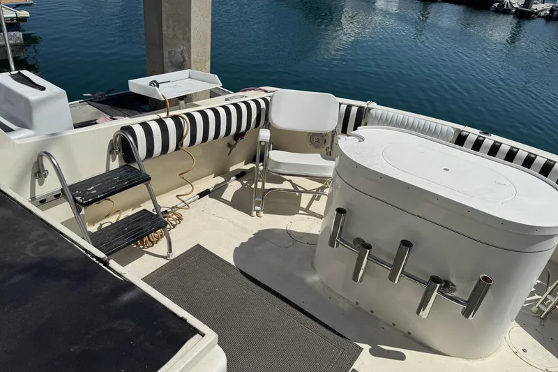 1985 Hatteras 45 Convertible boat deck with seating and fishing rod holders.