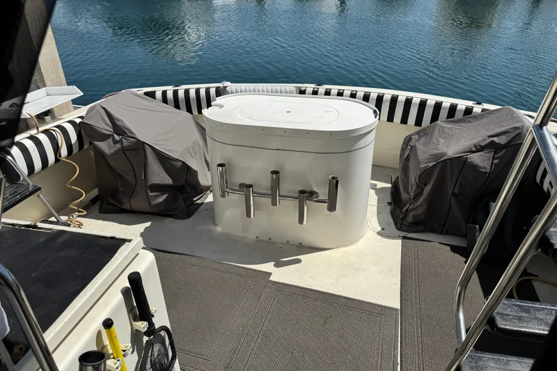 1985 Hatteras 45 Convertible boat deck with covered seating and fishing rod holders.