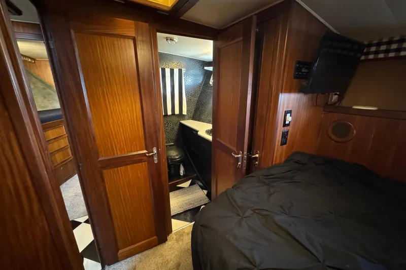 Interior of 1985 Hatteras 45 Convertible yacht with wood paneling and compact bathroom.