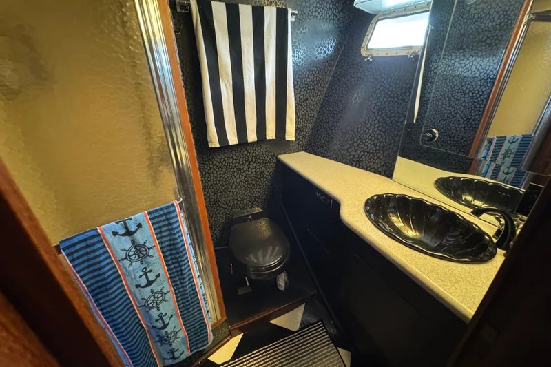 Bathroom interior of 1985 Hatteras 45 Convertible yacht with nautical decor.
