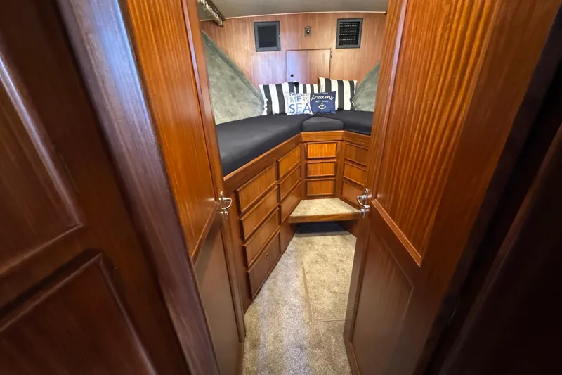 1985 Hatteras 45 Convertible cabin interior with wood paneling and nautical-themed pillows.