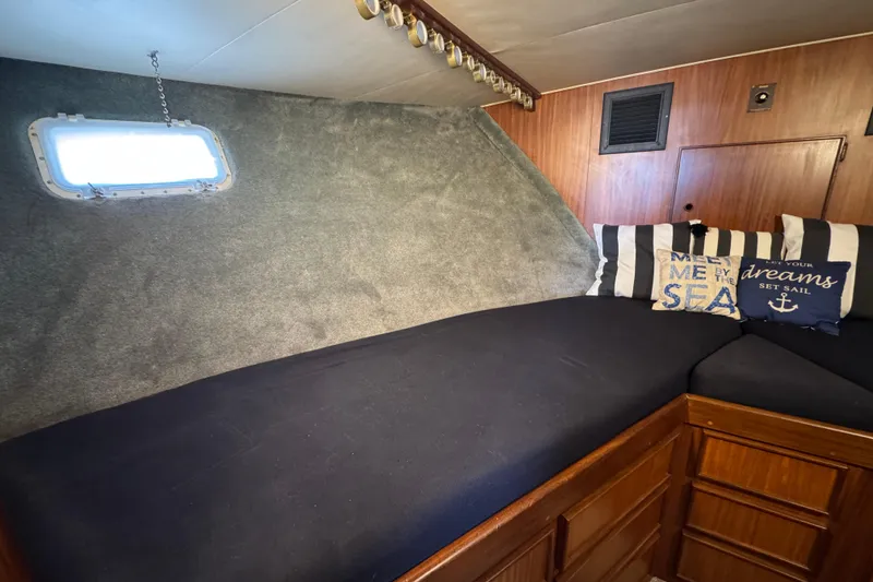 Cozy cabin interior of 1985 Hatteras 45 Convertible yacht with nautical-themed pillows.