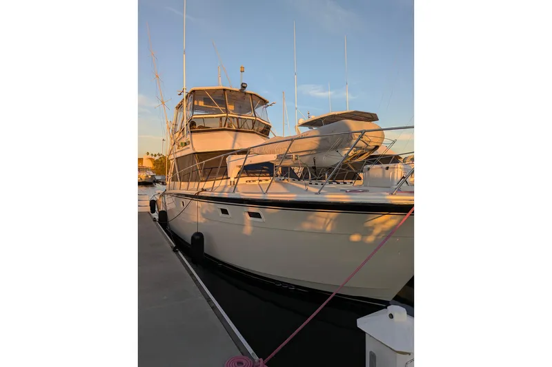 1985 Hatteras 45 Convertible yacht docked at sunset, showcasing sleek design and structure.