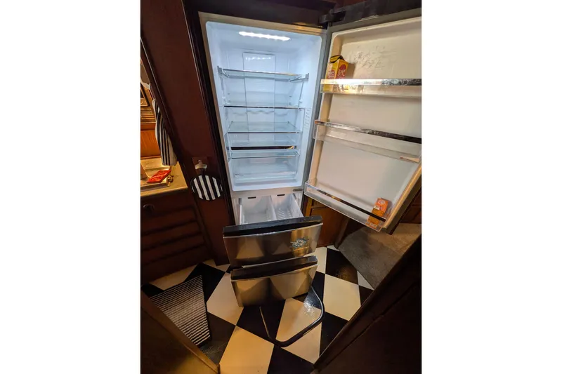 Open refrigerator inside 1985 Hatteras 45 Convertible yacht, showcasing spacious interior and modern design.