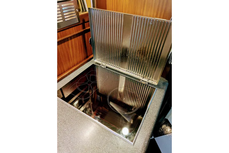 Stovetop in 1985 Hatteras 45 Convertible yacht kitchen, featuring sleek metallic design.