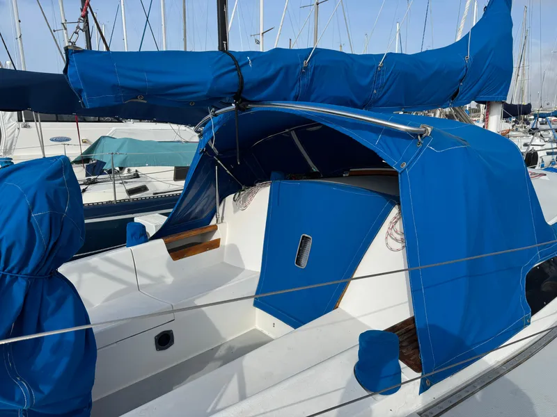 1990 Catalina 30 MkII sailboat with blue covers docked at marina.